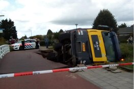 Betonmixer zakt door fietsbrug en belandt in de sloot