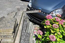 Inparkeren gaat mis, brommobiel eindigt in tuintje