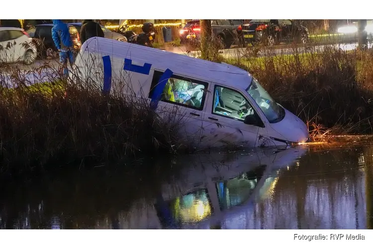 Bedrijfsbus ramt verkeerspaal en belandt in het water