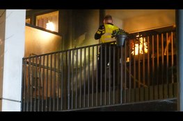 Brandend teunmeubilair van balkon naar beneden gegooid