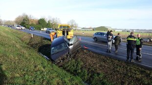 Modder op de weg, auto in de greppel